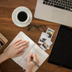Writer with notebook and laptop and coffee