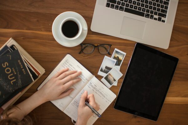 Writer with notebook and laptop and coffee